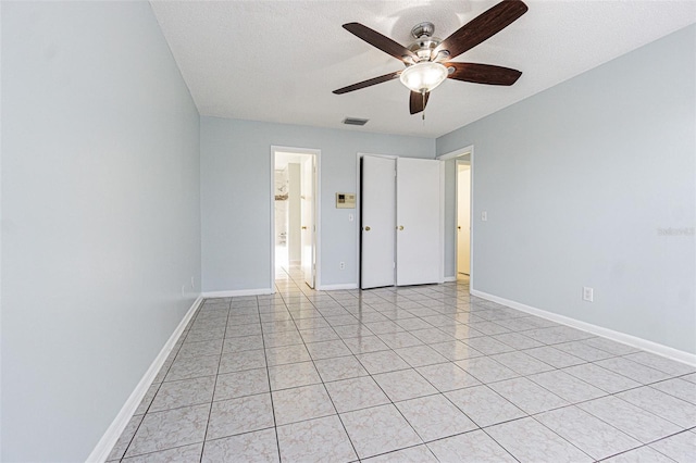 unfurnished bedroom with light tile patterned floors, visible vents, baseboards, and a textured ceiling