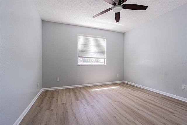 unfurnished room with baseboards, a textured ceiling, light wood-style floors, and ceiling fan