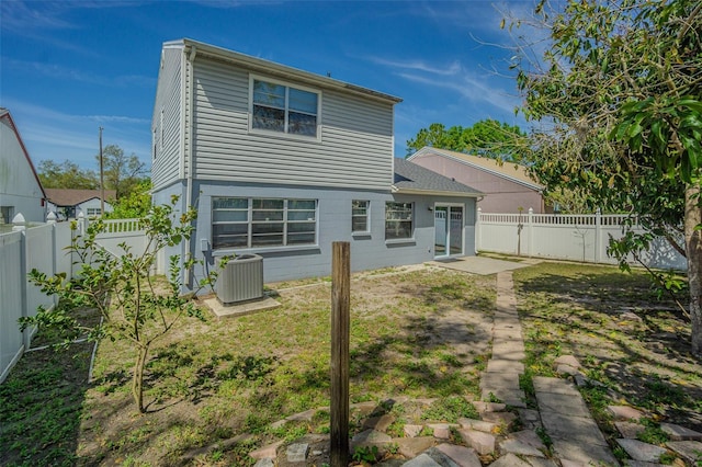 rear view of property with a lawn, cooling unit, and a fenced backyard