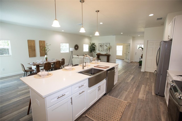 9445 Eldridge Rd, Spring Hill, FL 34608 - kitchen with stainless steel appliances, open floor plan, white cabinets, recessed lighting, and a center island with sink