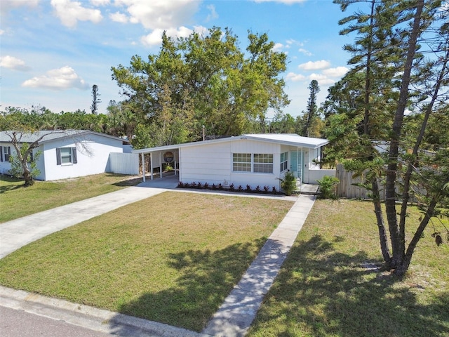 view of front of house featuring an attached carport, concrete driveway, fence, and a front lawn