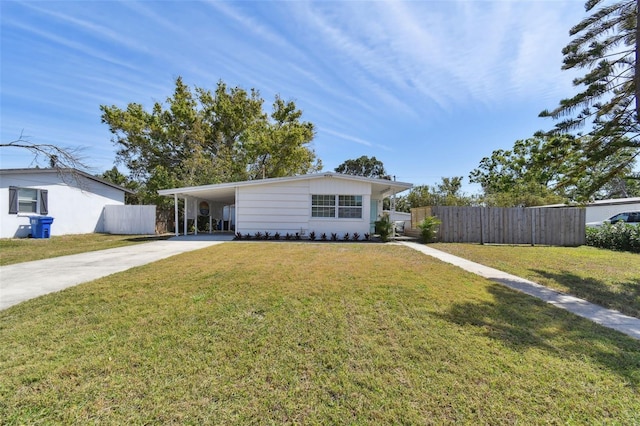 ranch-style home featuring a carport, driveway, a front yard, and fence