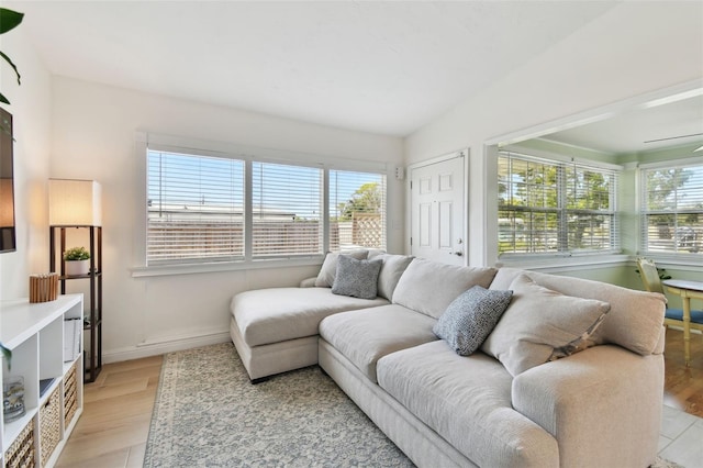 living area with light wood finished floors, a healthy amount of sunlight, and baseboards