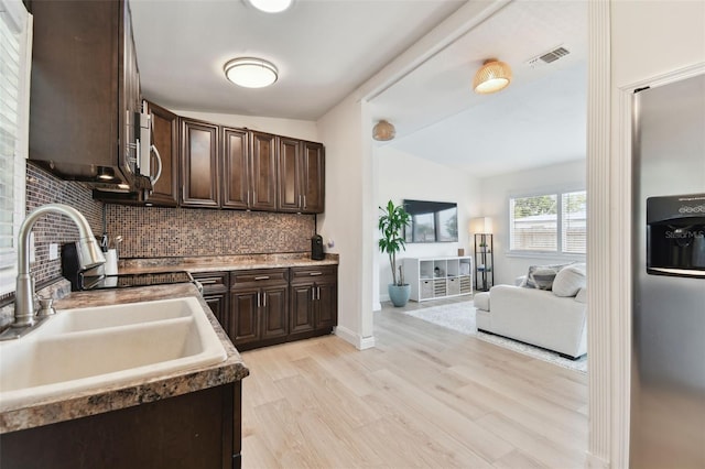 kitchen featuring a sink, visible vents, light wood-type flooring, and dark brown cabinetry
