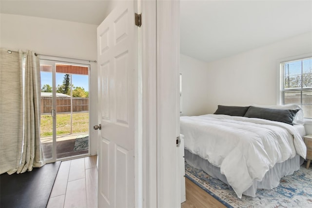 bedroom with wood finished floors and access to outside