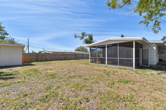 view of yard featuring a sunroom and fence