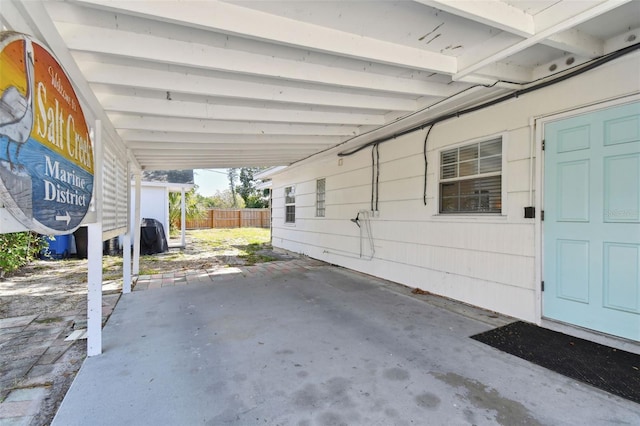 view of patio / terrace with a carport and fence