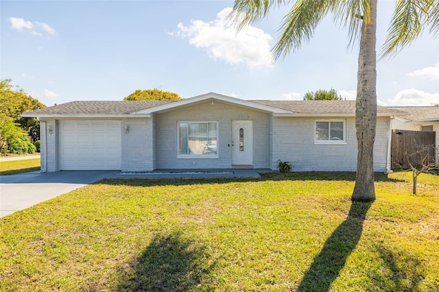 ranch-style house featuring a front yard, an attached garage, brick siding, and driveway