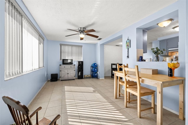 dining area with light tile patterned floors, a ceiling fan, visible vents, and a textured ceiling