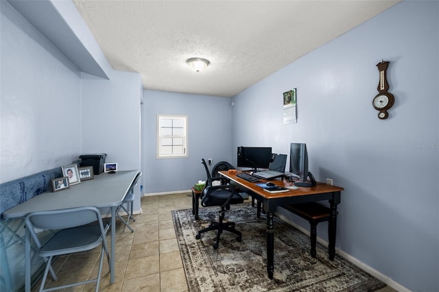 office space with light tile patterned flooring, a textured ceiling, and baseboards