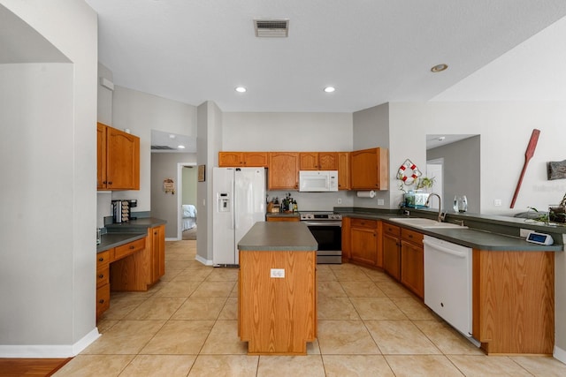 5123 Whispering Leaf Trl, Valrico, FL 33596 - kitchen with white appliances, visible vents, a sink, a kitchen island, and dark countertops