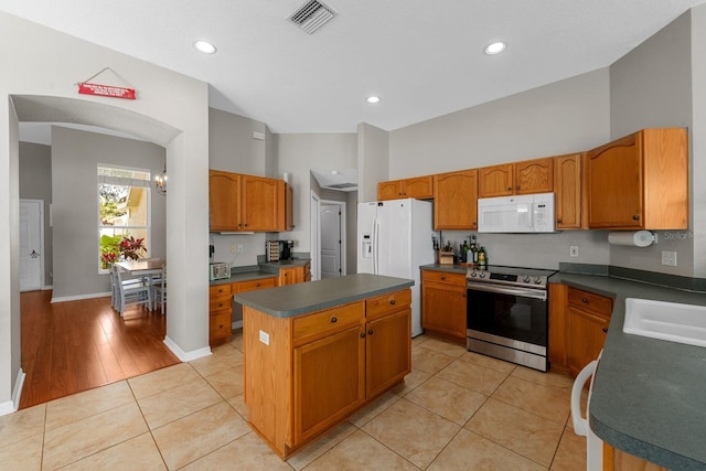 5123 Whispering Leaf Trl, Valrico, FL 33596 - kitchen featuring a sink, white appliances, visible vents, a kitchen island, and dark countertops