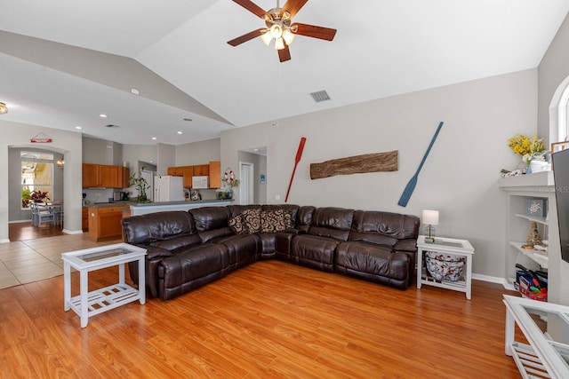 5123 Whispering Leaf Trl, Valrico, FL 33596 - living area featuring light wood-type flooring, visible vents, baseboards, ceiling fan, and vaulted ceiling