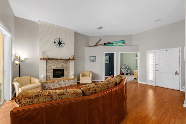 5123 Whispering Leaf Trl, Valrico, FL 33596 - living area with light wood-style flooring, a stone fireplace, and vaulted ceiling