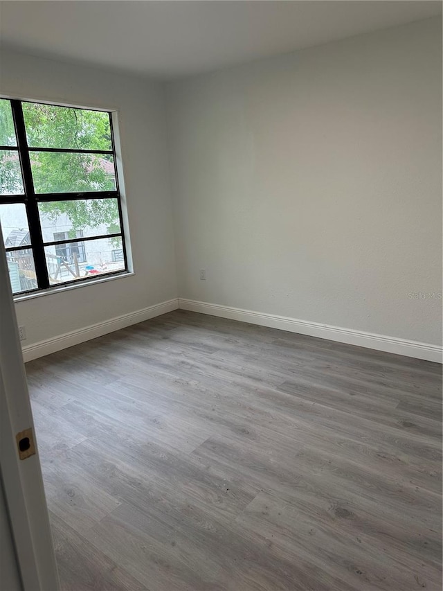 10216 N Pawnee Ave, Tampa, FL 33617 - spare room featuring wood finished floors and baseboards