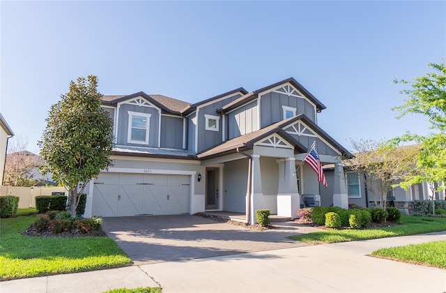 view of front of house with an attached garage, driveway, board and batten siding, and fence