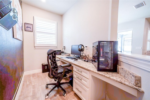 office area featuring visible vents, light wood-type flooring, and baseboards