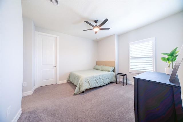 carpeted bedroom with visible vents, baseboards, and ceiling fan