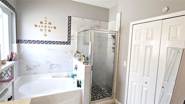 full bathroom featuring a closet, a shower stall, and a garden tub