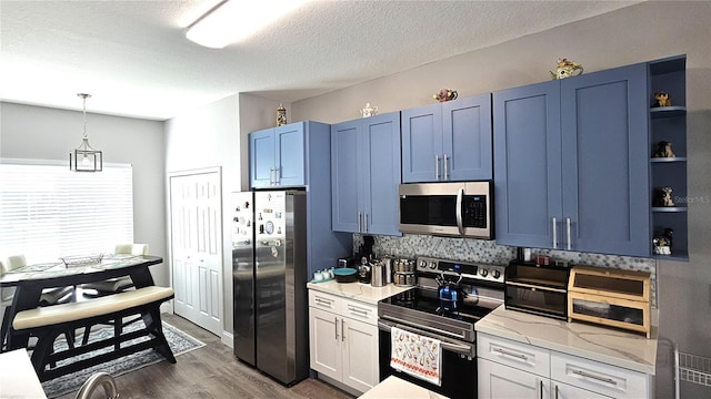 kitchen with blue cabinetry, dark wood-type flooring, pendant lighting, stainless steel appliances, and open shelves