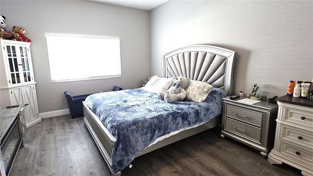 bedroom with baseboards and dark wood-style flooring