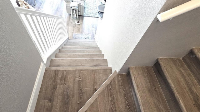 staircase with baseboards and a textured wall