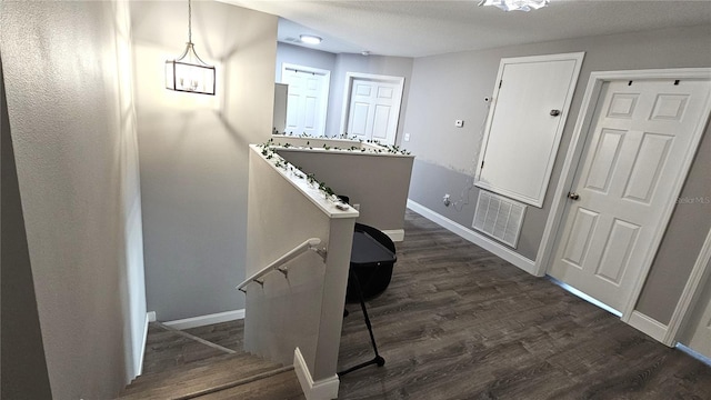 stairway featuring visible vents, baseboards, and wood finished floors