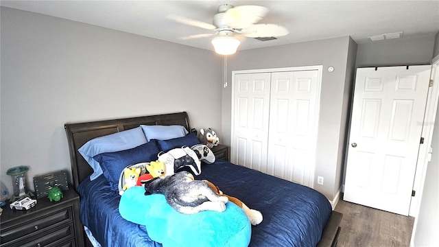 bedroom featuring a ceiling fan, wood finished floors, visible vents, and a closet