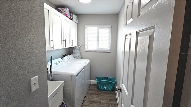 laundry room with baseboards, cabinet space, dark wood-style flooring, a sink, and washer and clothes dryer