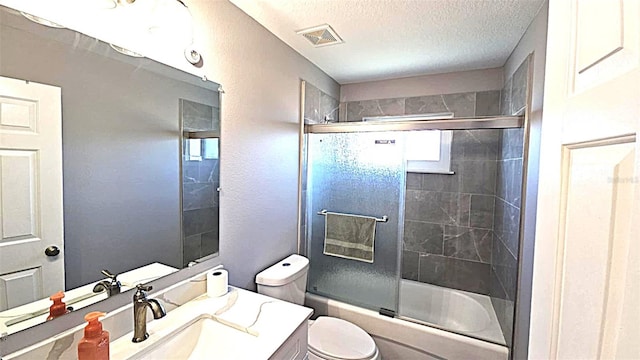 25631 Bruford Blvd, Land O Lakes, FL 34639 - full bathroom with toilet, vanity, shower / bath combination with glass door, and a textured ceiling