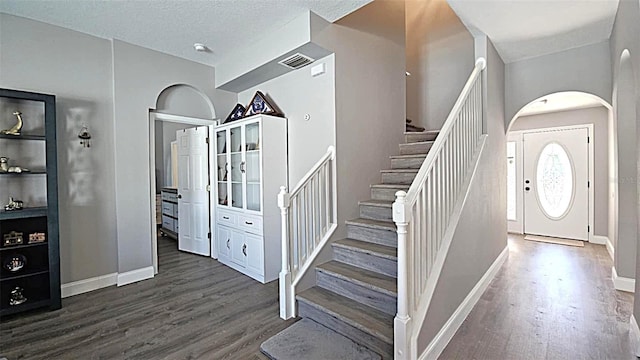 25631 Bruford Blvd, Land O Lakes, FL 34639 - entryway featuring dark wood finished floors, stairs, baseboards, and arched walkways