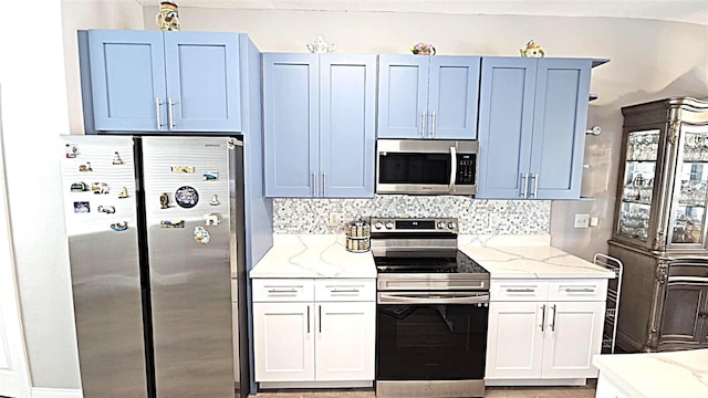 25631 Bruford Blvd, Land O Lakes, FL 34639 - kitchen featuring stainless steel appliances, light stone counters, and decorative backsplash
