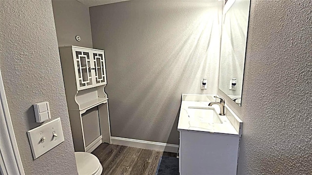 25631 Bruford Blvd, Land O Lakes, FL 34639 - bathroom featuring wood finished floors, vanity, toilet, a textured wall, and baseboards