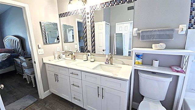 25631 Bruford Blvd, Land O Lakes, FL 34639 - full bath featuring double vanity, toilet, connected bathroom, wood finished floors, and baseboards