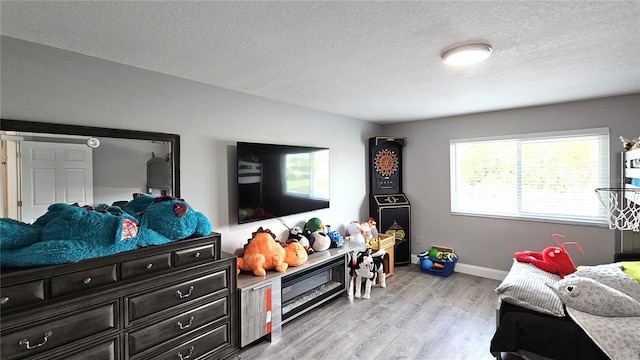 25631 Bruford Blvd, Land O Lakes, FL 34639 - bedroom featuring light wood-style floors, a textured ceiling, and baseboards