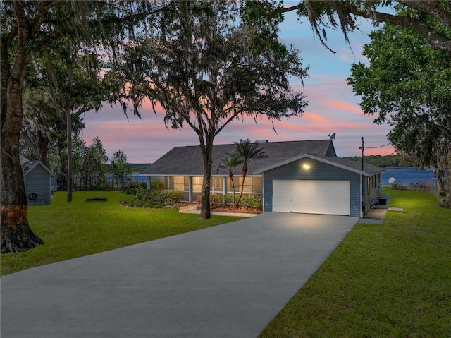 ranch-style house featuring a yard, an attached garage, and driveway