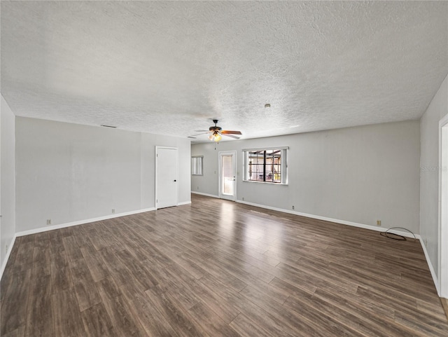 unfurnished living room with baseboards, a textured ceiling, dark wood-type flooring, and ceiling fan
