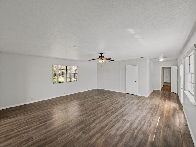 unfurnished living room featuring baseboards, a ceiling fan, and dark wood-style flooring