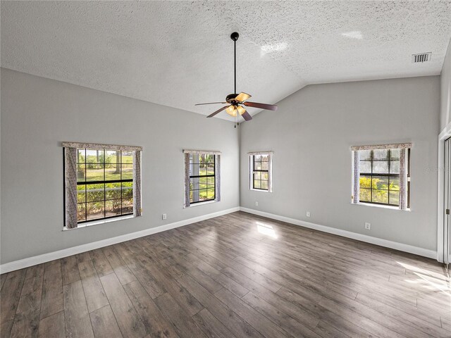 empty room with visible vents, baseboards, ceiling fan, dark wood finished floors, and lofted ceiling