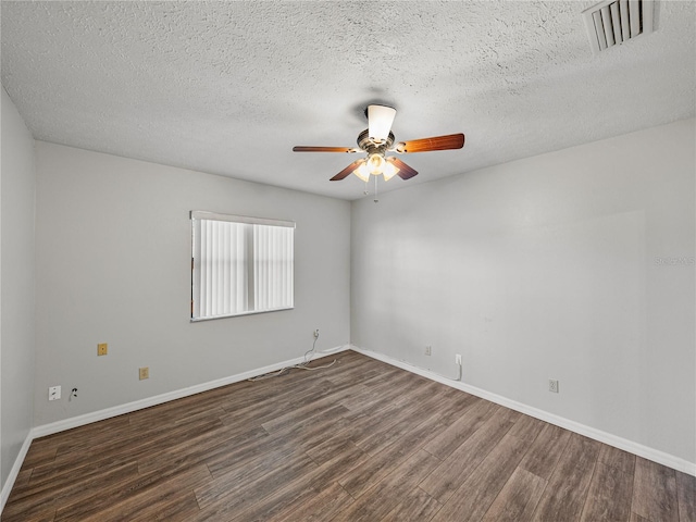empty room featuring visible vents, baseboards, dark wood-style floors, and a ceiling fan