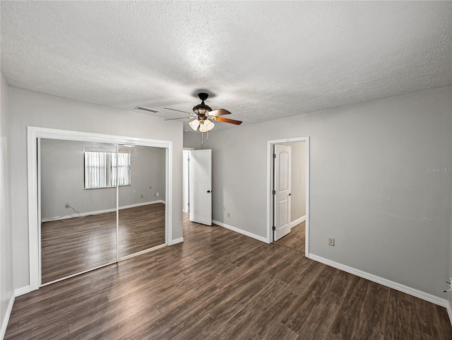 unfurnished bedroom featuring visible vents, a ceiling fan, a closet, baseboards, and dark wood-style flooring