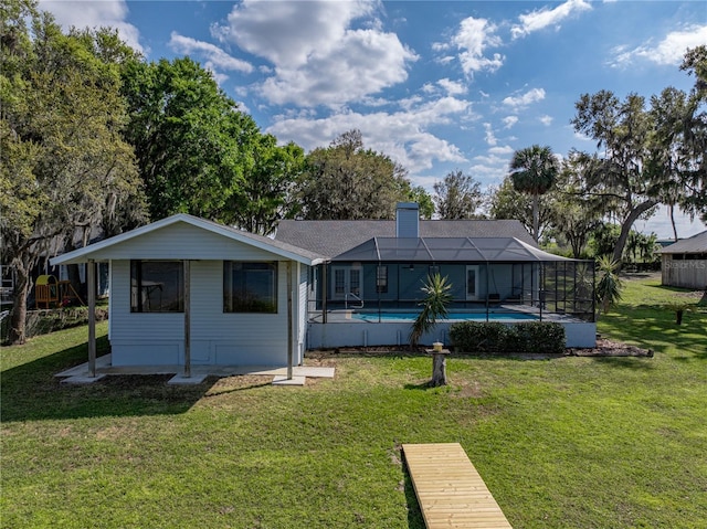 back of property with a lanai, a lawn, an outdoor pool, and a chimney