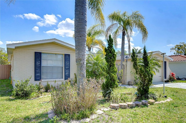 view of front of property with concrete driveway, fence, and brick siding