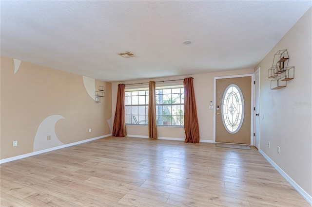 foyer with visible vents, light wood-style floors, and baseboards