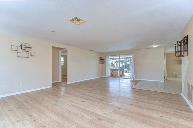 spare room with visible vents, baseboards, and light wood-style floors