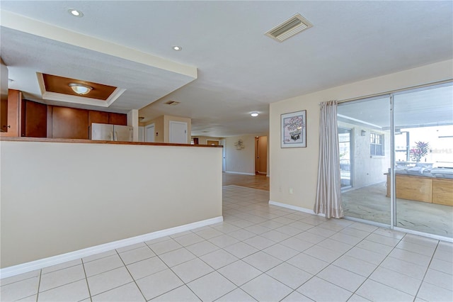 spare room featuring light tile patterned flooring, baseboards, and visible vents