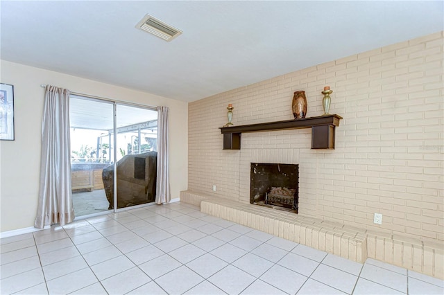 unfurnished living room with light tile patterned floors, visible vents, brick wall, and a fireplace