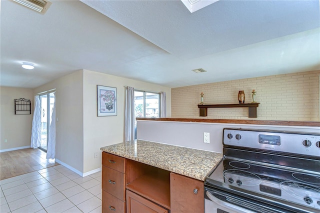 kitchen with open shelves, electric range, light tile patterned floors, and visible vents