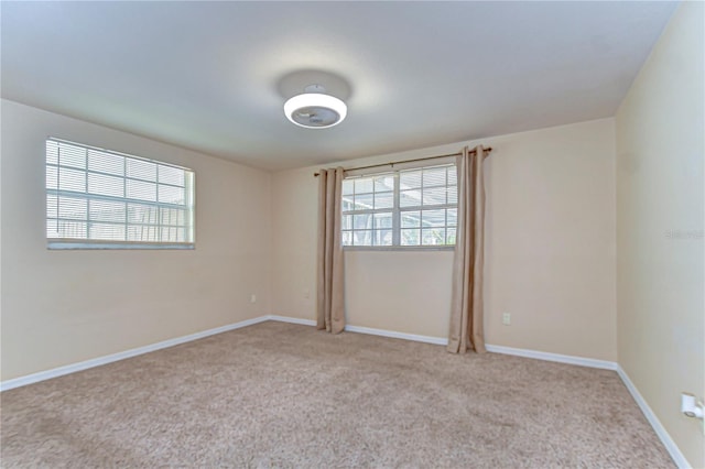 carpeted empty room with baseboards