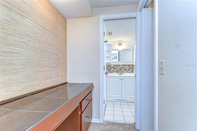 bathroom with vanity, visible vents, and tasteful backsplash